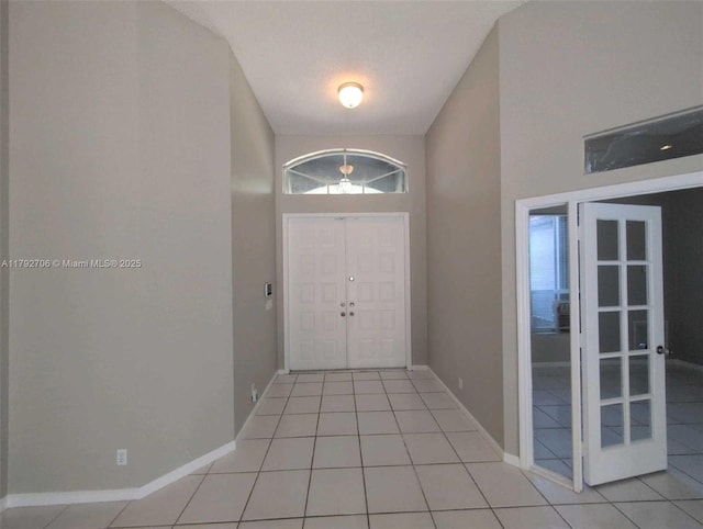 foyer entrance with baseboards and light tile patterned floors