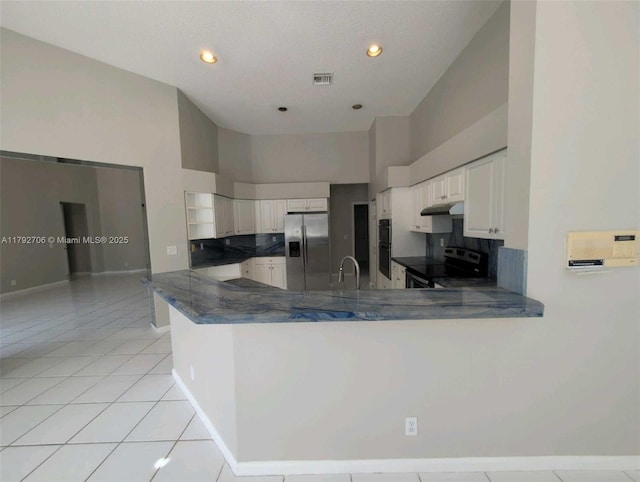 kitchen with under cabinet range hood, a peninsula, range with electric cooktop, and stainless steel fridge