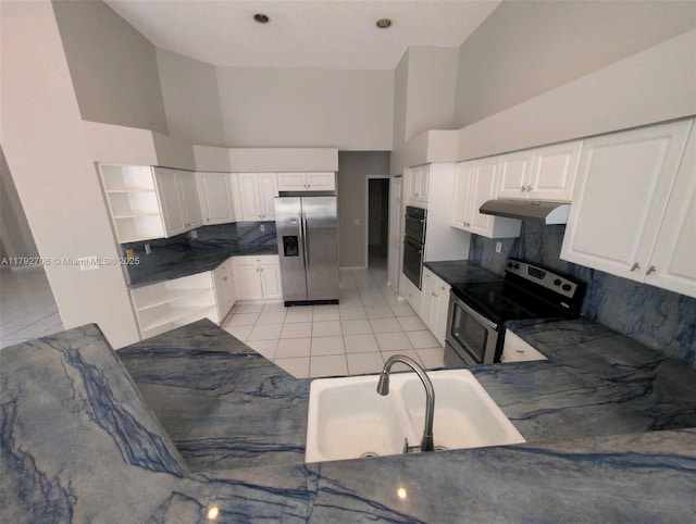 kitchen featuring dark countertops, high vaulted ceiling, under cabinet range hood, a sink, and stainless steel appliances