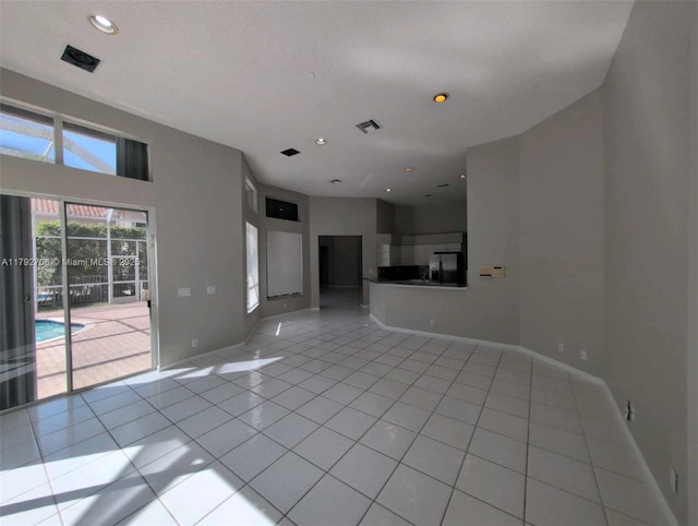 unfurnished living room with baseboards, recessed lighting, and light tile patterned flooring