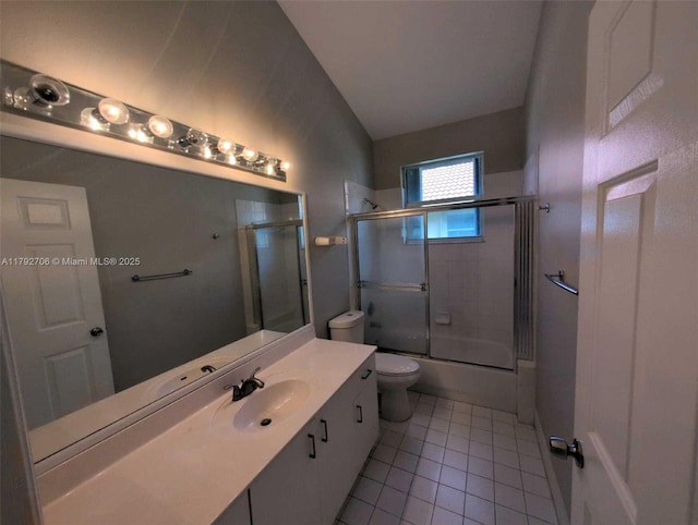 bathroom with tile patterned flooring, vaulted ceiling, vanity, combined bath / shower with glass door, and toilet