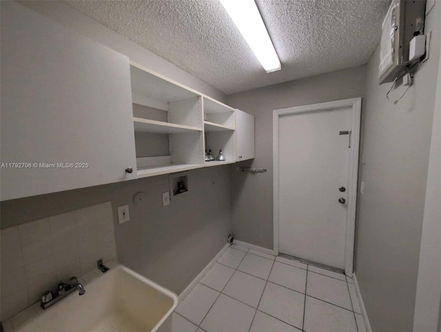 laundry room with washer hookup, laundry area, a textured ceiling, light tile patterned floors, and baseboards