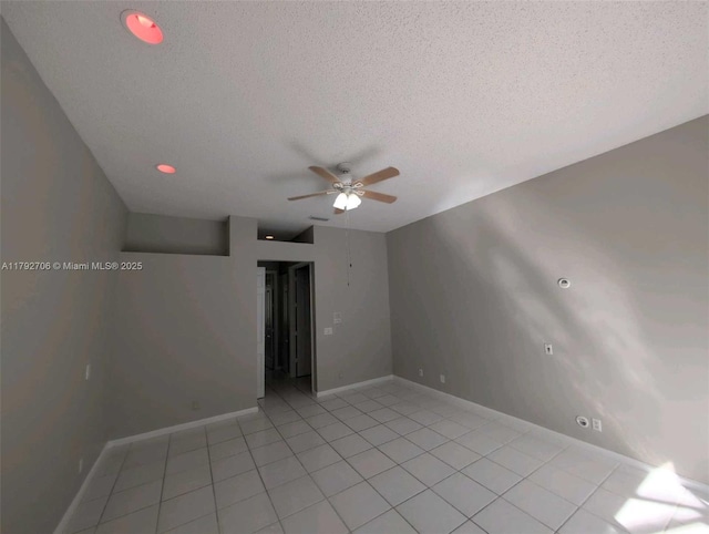 spare room with baseboards, a ceiling fan, a textured ceiling, and light tile patterned floors