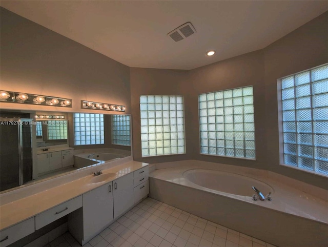 bathroom featuring tile patterned floors, plenty of natural light, a bath, and visible vents