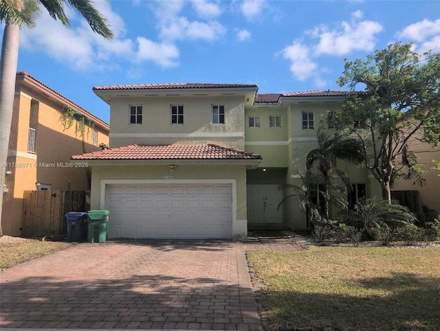 mediterranean / spanish house with decorative driveway, stucco siding, and a tiled roof