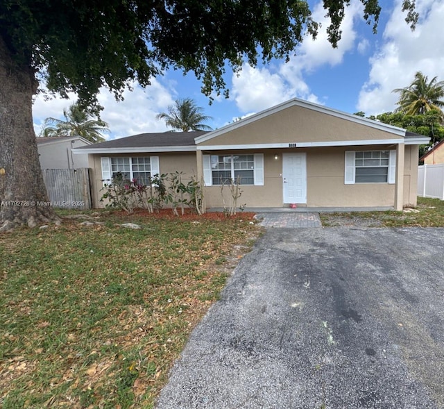 view of front facade with fence and stucco siding