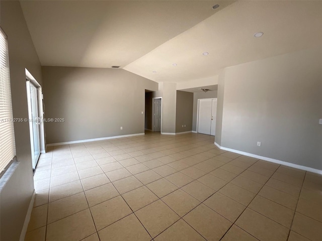 unfurnished room featuring light tile patterned floors, baseboards, vaulted ceiling, and visible vents