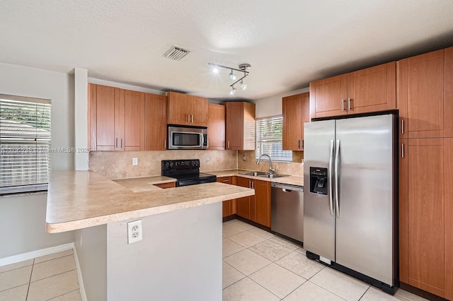 12846 SW 211th Ter, Miami, FL 33177 - kitchen with appliances with stainless steel finishes, light tile patterned flooring, a peninsula, light countertops, and a sink