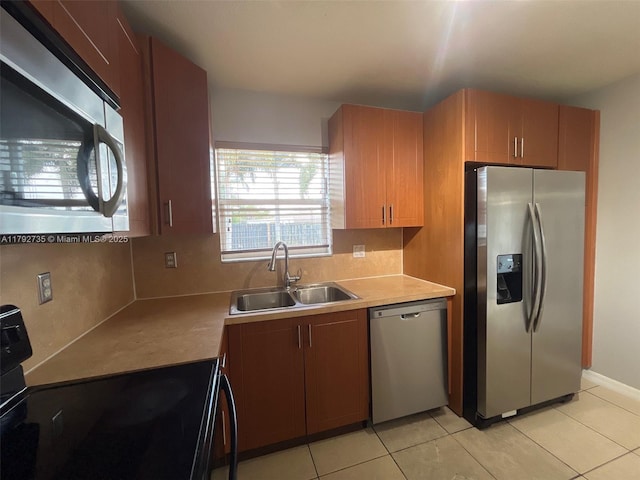 kitchen featuring a sink, appliances with stainless steel finishes, backsplash, and light tile patterned floors