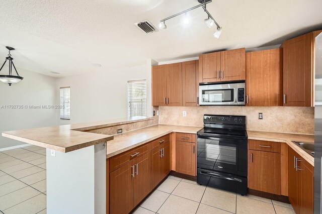 12846 SW 211th Ter, Miami, FL 33177 - kitchen with stainless steel microwave, electric range, a peninsula, and light tile patterned floors