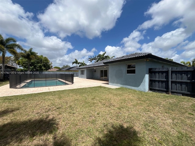 view of swimming pool featuring a fenced backyard, a fenced in pool, a lawn, and a patio area