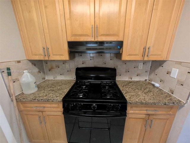 kitchen featuring black range with gas stovetop, light brown cabinetry, backsplash, and under cabinet range hood