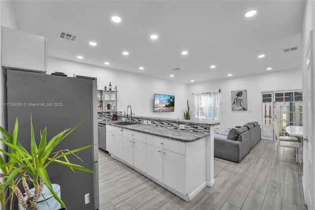 2307 Washington St Unit 5, Hollywood, FL 33020 - kitchen with appliances with stainless steel finishes, white cabinets, a peninsula, light wood finished floors, and recessed lighting