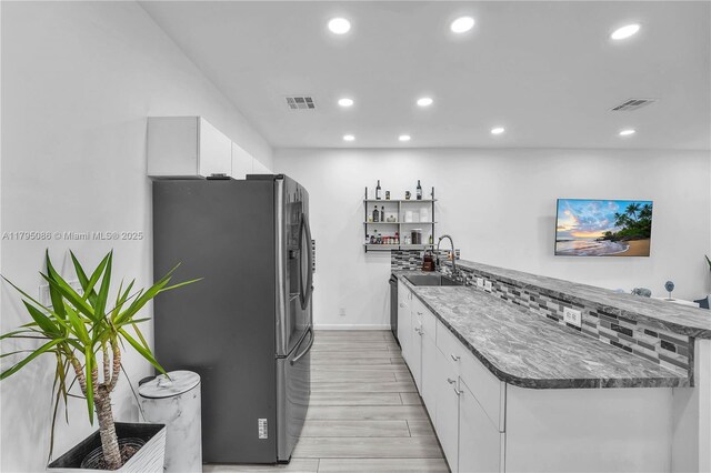 2307 Washington St Unit 5, Hollywood, FL 33020 - kitchen with stainless steel fridge with ice dispenser, white cabinetry, light wood-style flooring, recessed lighting, and a peninsula