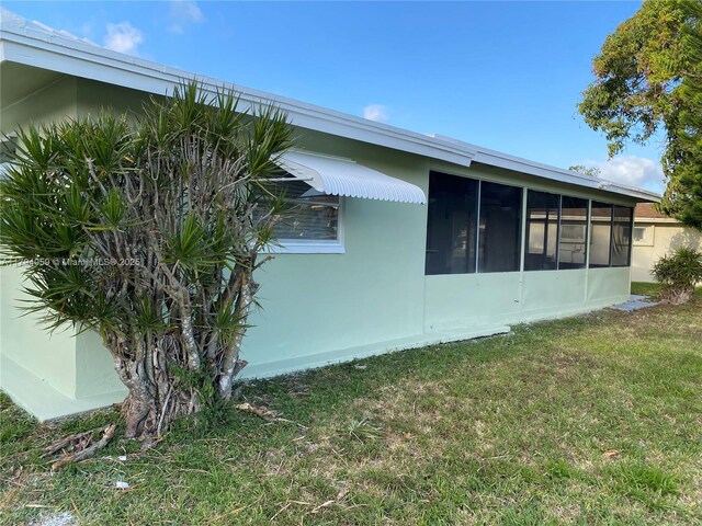 5009 NW 51st Ct, Tamarac, FL 33319 - view of home's exterior featuring a lawn, a sunroom, and stucco siding