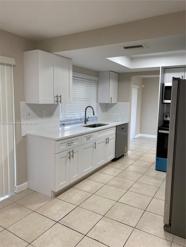 5009 NW 51st Ct, Tamarac, FL 33319 - kitchen featuring visible vents, light countertops, tasteful backsplash, a sink, and appliances with stainless steel finishes