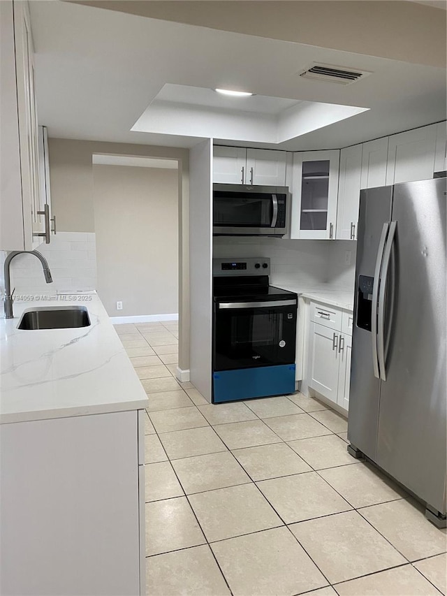 5009 NW 51st Ct, Tamarac, FL 33319 - kitchen featuring a tray ceiling, decorative backsplash, visible vents, a sink, and stainless steel appliances