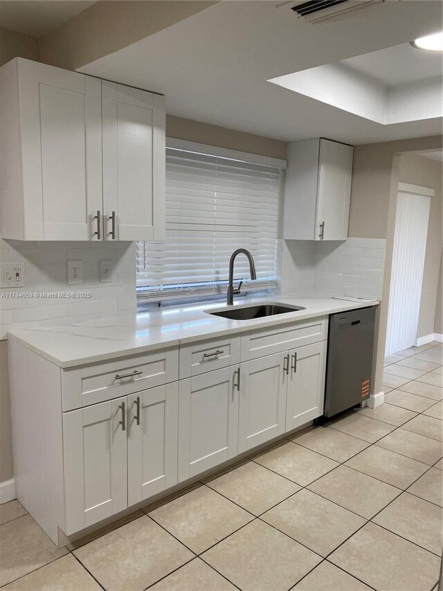 5009 NW 51st Ct, Tamarac, FL 33319 - kitchen with decorative backsplash, light countertops, white cabinetry, a sink, and dishwasher