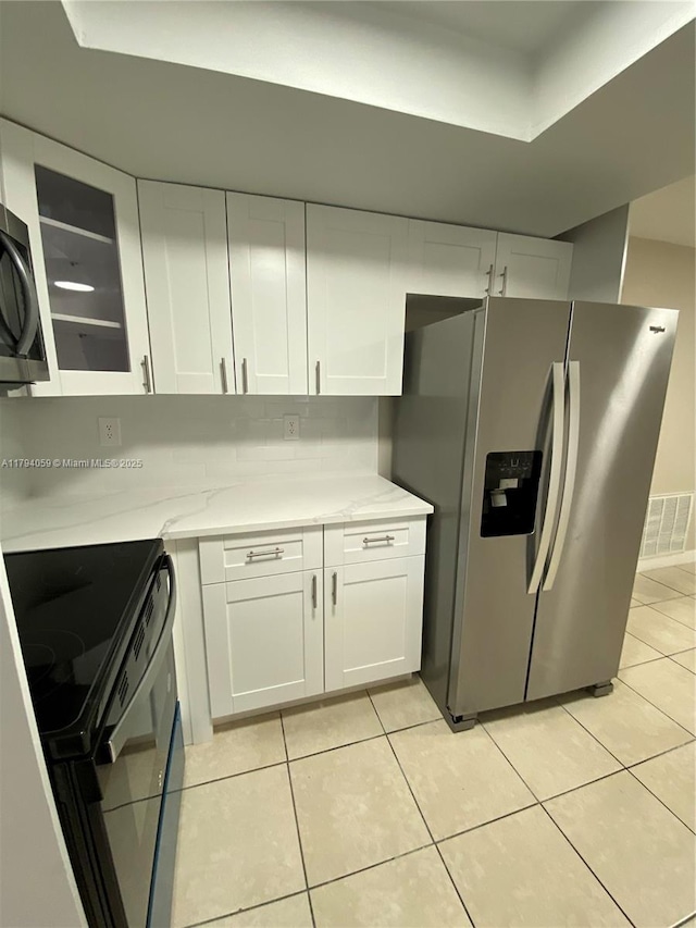 5009 NW 51st Ct, Tamarac, FL 33319 - kitchen featuring visible vents, stainless steel fridge, light countertops, white cabinets, and black electric range