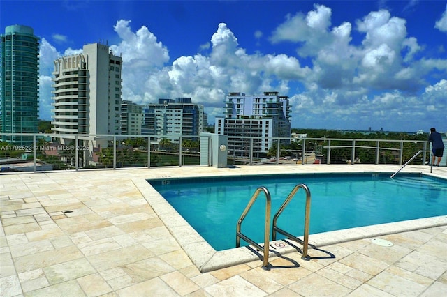 pool with a view of city and a patio area