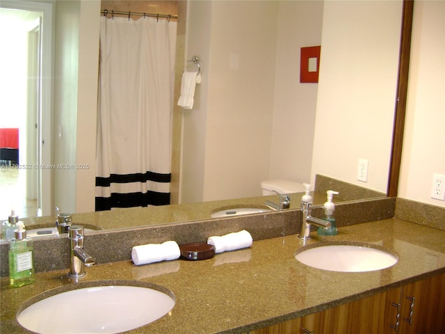 bathroom with a sink, a shower with curtain, and double vanity