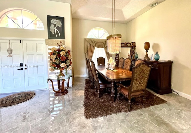 12022 Classic Dr, Coral Springs, FL 33071 - dining space featuring marble finish floors, a textured ceiling, and a tray ceiling