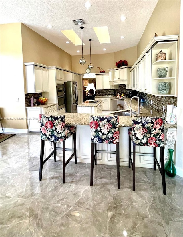 12022 Classic Dr, Coral Springs, FL 33071 - kitchen featuring stainless steel appliances, a sink, a peninsula, tasteful backsplash, and a textured ceiling
