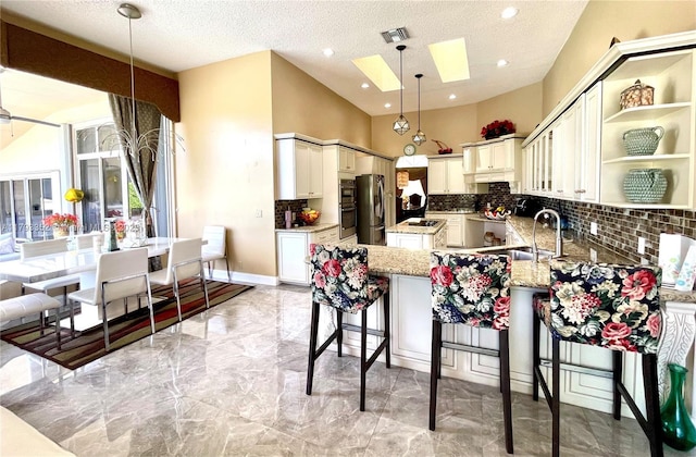 12022 Classic Dr, Coral Springs, FL 33071 - kitchen featuring freestanding refrigerator, light marble finish flooring, decorative backsplash, light stone counters, and a peninsula