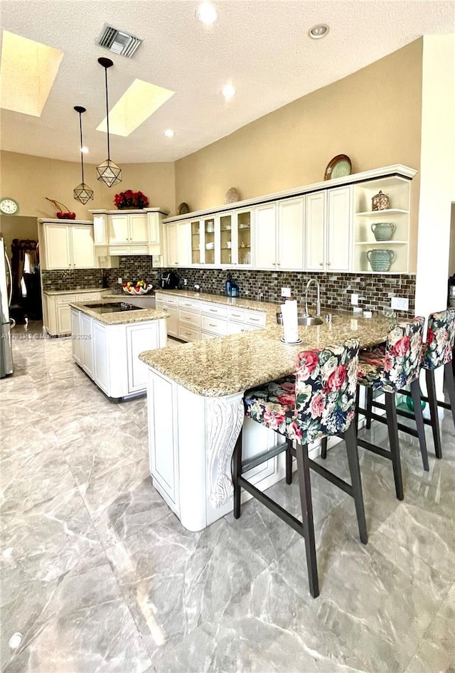 12022 Classic Dr, Coral Springs, FL 33071 - kitchen with a skylight, backsplash, freestanding refrigerator, a peninsula, and open shelves