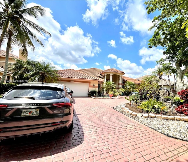 12022 Classic Dr, Coral Springs, FL 33071 - mediterranean / spanish-style house featuring stucco siding, decorative driveway, an attached garage, and a tile roof
