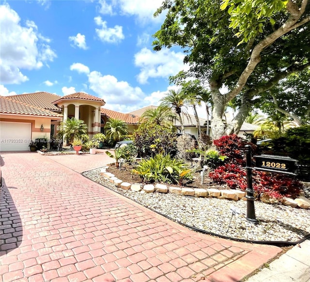 12022 Classic Dr, Coral Springs, FL 33071 - mediterranean / spanish house with decorative driveway, a tile roof, stucco siding, and a garage