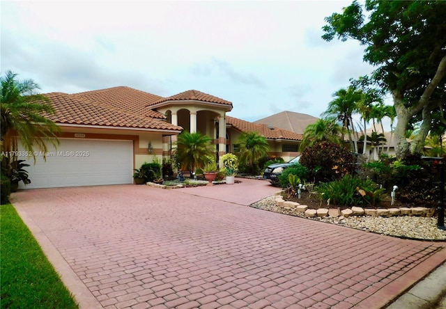 12022 Classic Dr, Coral Springs, FL 33071 - mediterranean / spanish-style home with decorative driveway, an attached garage, stucco siding, and a tile roof