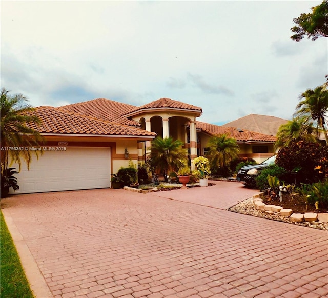 12022 Classic Dr, Coral Springs, FL 33071 - mediterranean / spanish-style home featuring driveway, an attached garage, stucco siding, and a tile roof