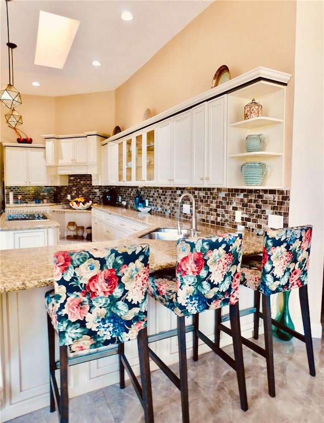 12022 Classic Dr, Coral Springs, FL 33071 - kitchen with a skylight, light stone countertops, decorative light fixtures, decorative backsplash, and recessed lighting