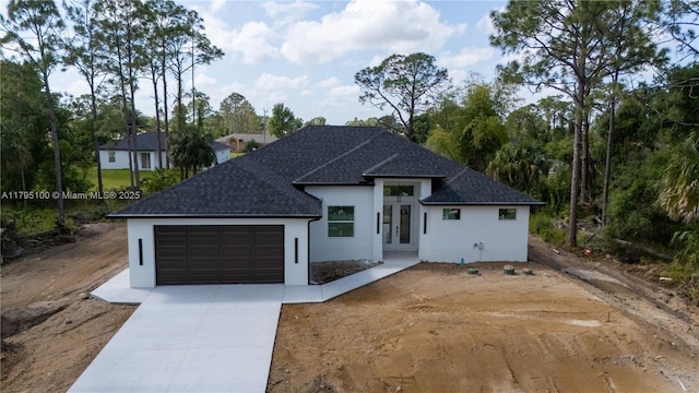 single story home featuring roof with shingles, an attached garage, stucco siding, french doors, and driveway
