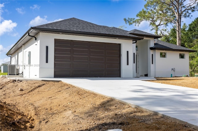 view of front facade featuring a garage, stucco siding, concrete driveway, and roof with shingles