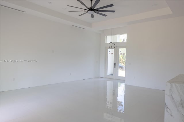 spare room featuring a raised ceiling and a ceiling fan