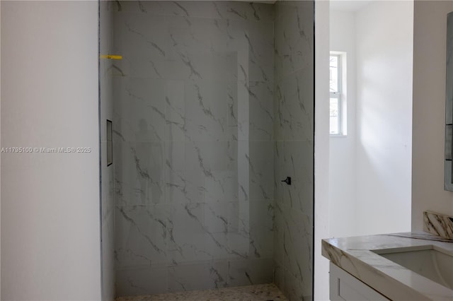 full bath with vanity and a marble finish shower