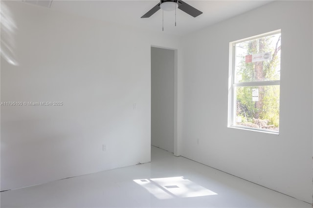empty room featuring a ceiling fan, visible vents, and plenty of natural light