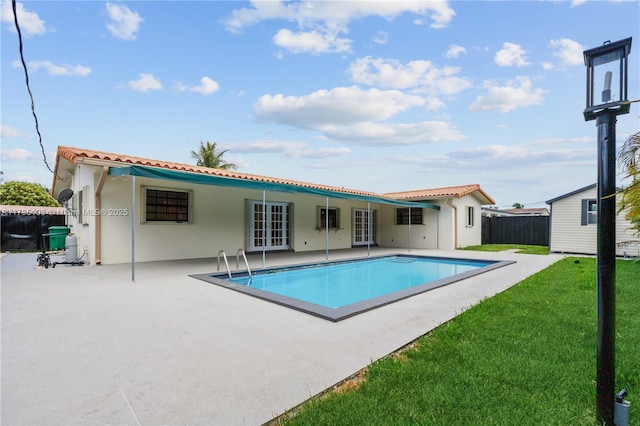 view of pool with fence, a patio, french doors, a fenced in pool, and a yard