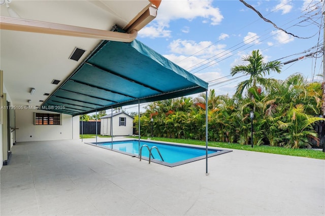 pool with a storage shed, a patio, fence, and an outbuilding
