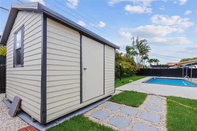 view of outdoor structure featuring a fenced in pool, a fenced backyard, and an outdoor structure