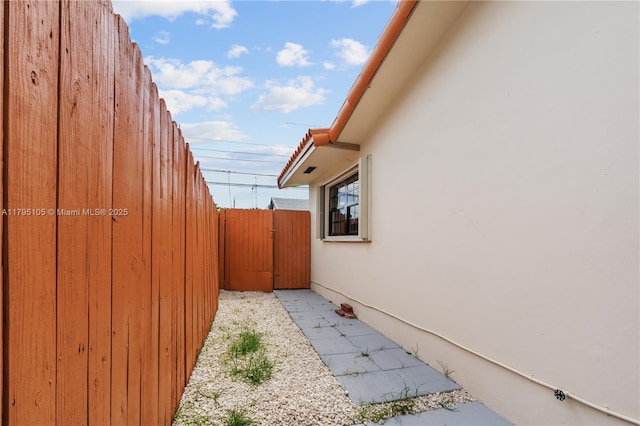 view of side of home with fence and stucco siding