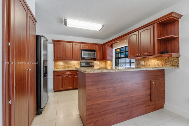 kitchen with light tile patterned floors, tasteful backsplash, stainless steel appliances, and a peninsula