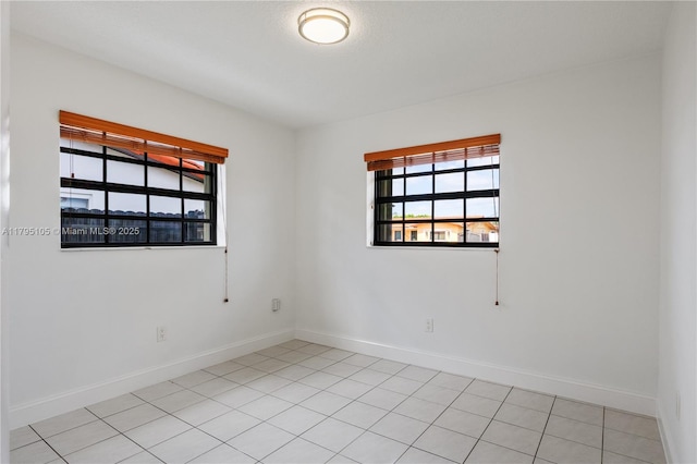 unfurnished room with baseboards and light tile patterned floors