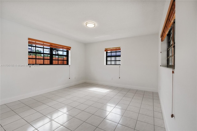 unfurnished room featuring plenty of natural light, baseboards, and light tile patterned floors