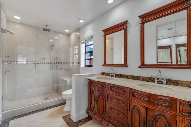 full bath with double vanity, toilet, a sink, and a stall shower