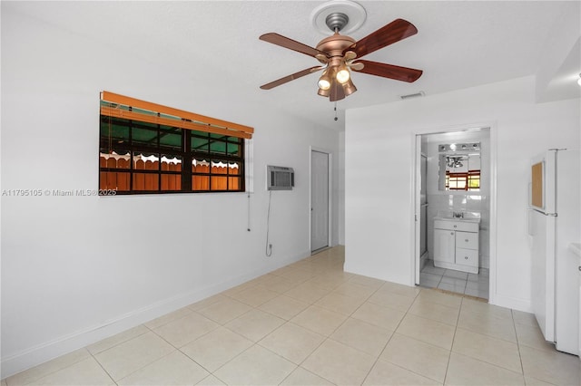 empty room featuring visible vents, baseboards, ceiling fan, a wall mounted AC, and tile patterned floors