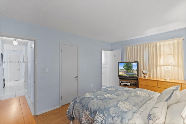 bedroom with baseboards and light wood finished floors