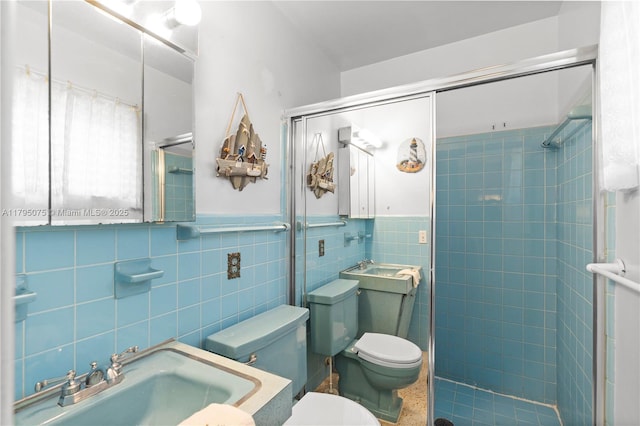 full bath with toilet, tile walls, a shower stall, and a sink